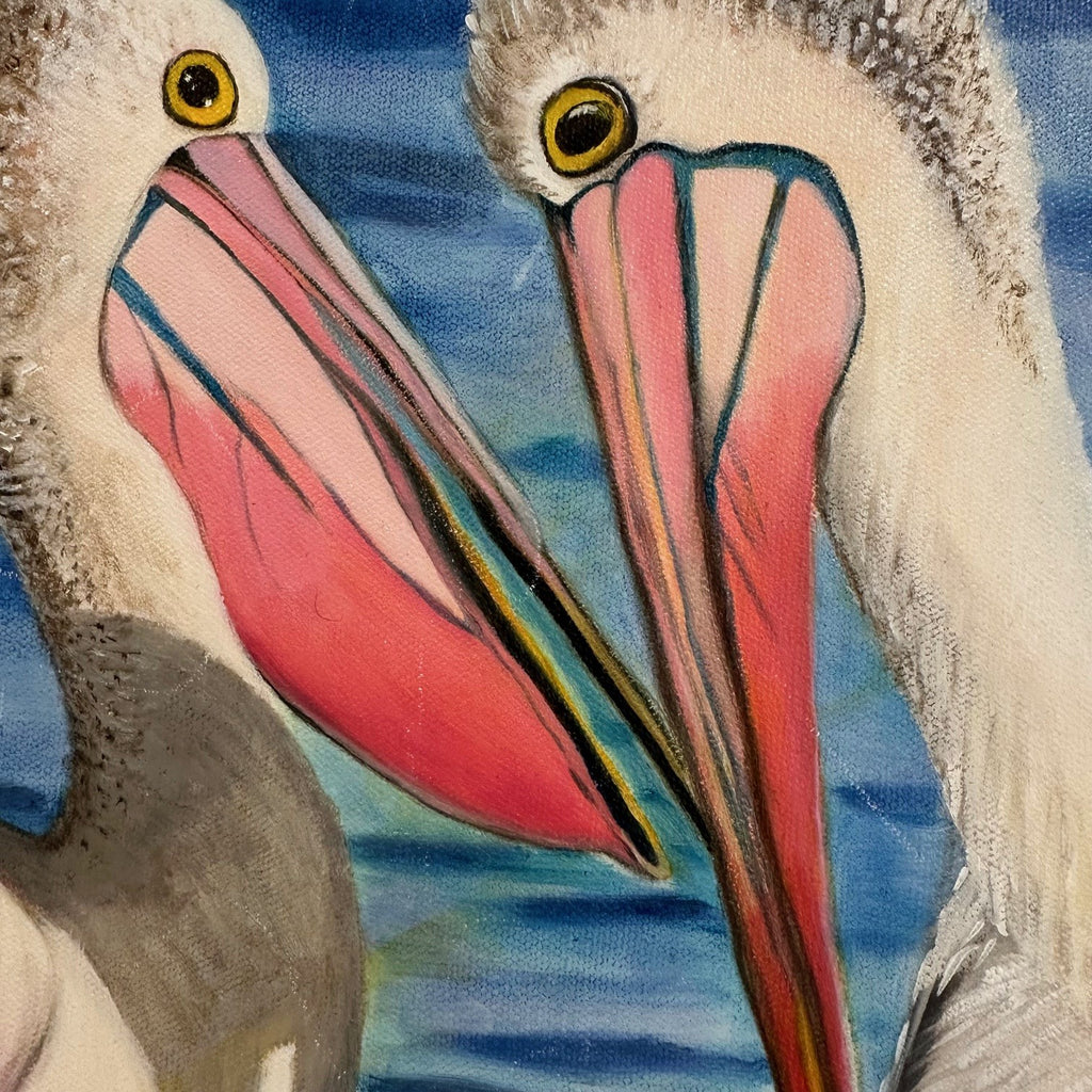 Close-up of a pelican with a colorful beak against a blue water background