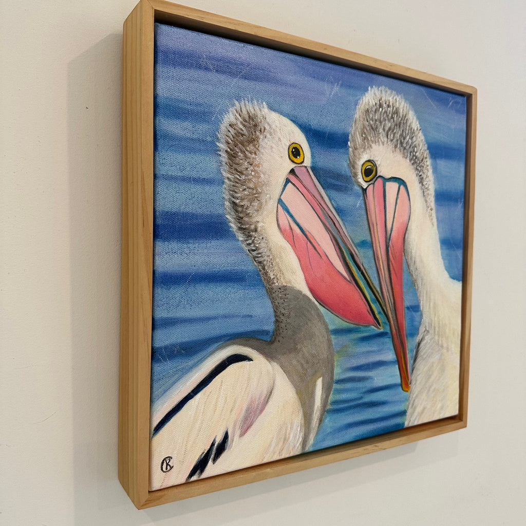 Framed artwork of two pelicans with a blue background