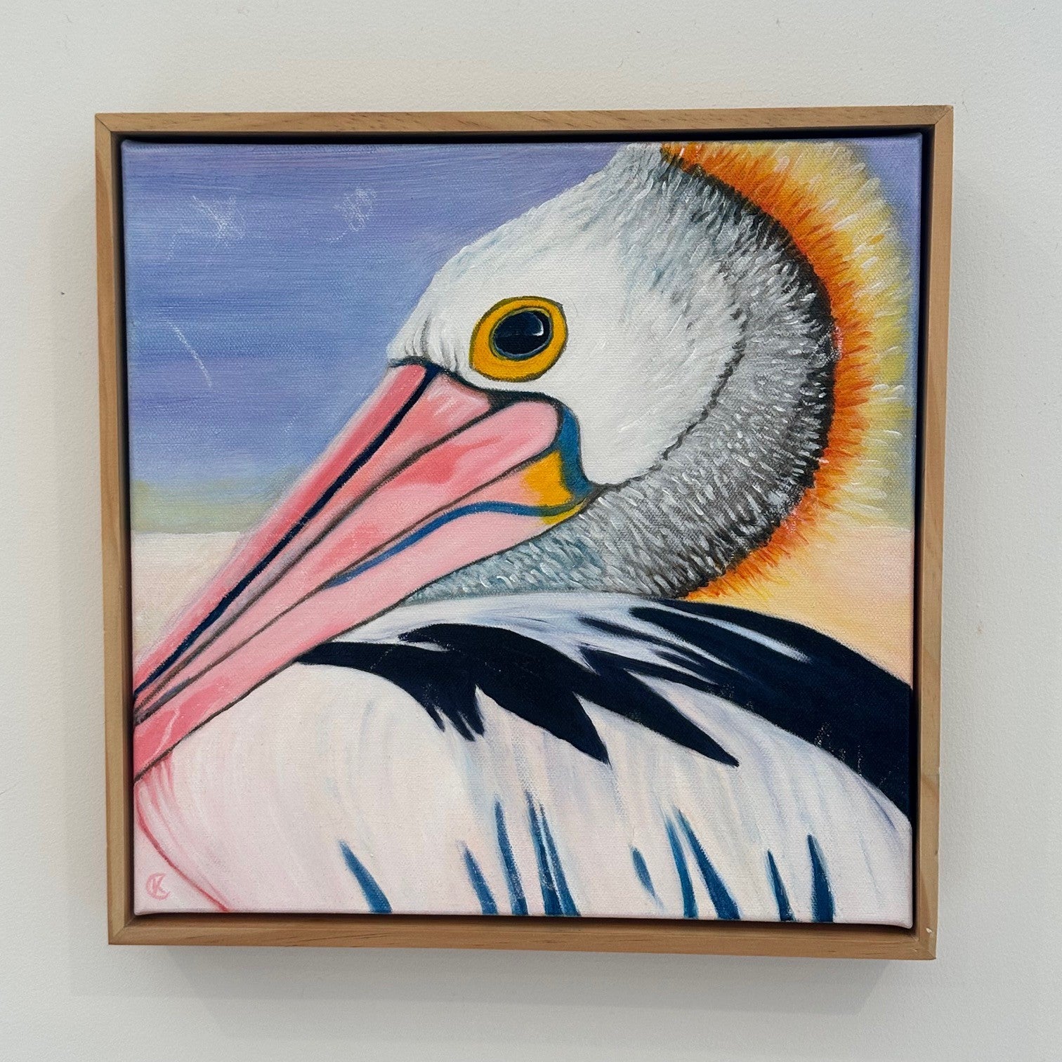 Framed painting of a pelican on a white wall